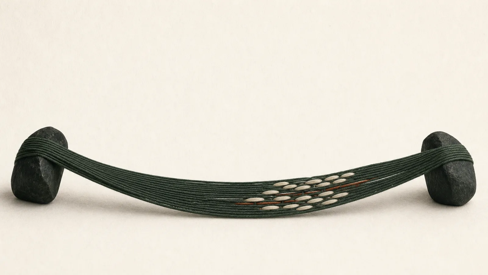 Dark green fibres stretch between two stone anchors, with a small section reinforced by pale and rust-coloured threads.